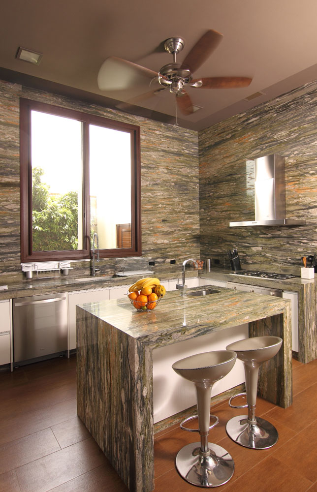 La cocina tiene las paredes de granito, de piso a techo, y modulares blancos de Hogar 2000