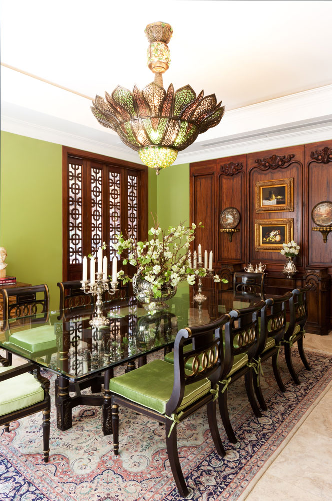 Verde, dorado y madera marcan en este comedor para diez personas. Un mueble auxiliar en madera hecho a medida adorna la pared.