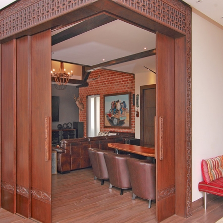 Las puertas que separan la sala principal de la de música son de madera corredizas. Arriba, guarda tallada.