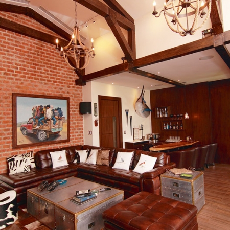 La sala de música es cómoda con mesa de juegos, sofás de cuero, mesón en madera, ladrillos en las paredes y llamativas vigas en el techo.
