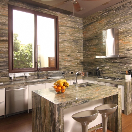 La cocina tiene las paredes de granito, de piso a techo, y modulares blancos de Hogar 2000