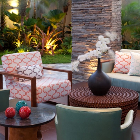 En el patio-galería se luce una mesa de zeike y otra auxiliar en teca. Dos sillas en cuero turquesa avivan el ambiente.
