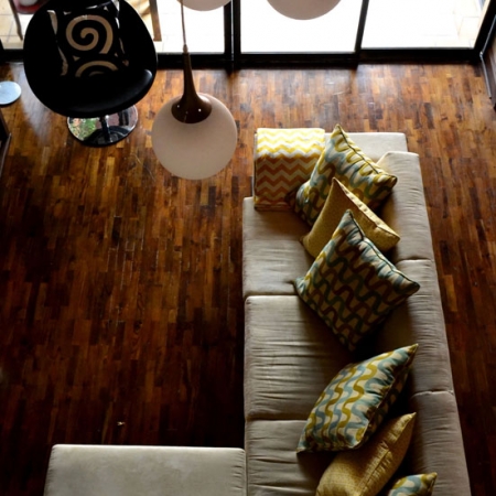 El modelo del sofá es de líneas rectas con una base alta de madera. Tela de microfibra, y almohadones de varios colores como acento